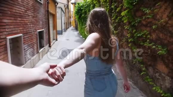 一个年轻的女人牵着她的男朋友穿过意大利的街道视频的预览图