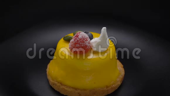 慕斯甜点覆盖着黄色的釉在黑色的盘子里旋转视频的预览图