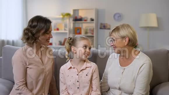 可爱的母亲和奶奶亲吻女儿的脸颊和拥抱女性世代视频的预览图