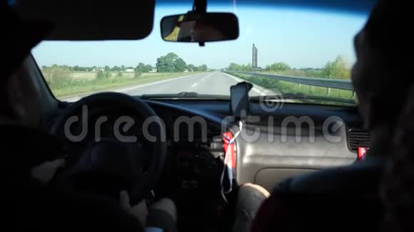 两个朋友在车里旅行这些家伙穿过农村司机看后视镜4K慢视频的预览图
