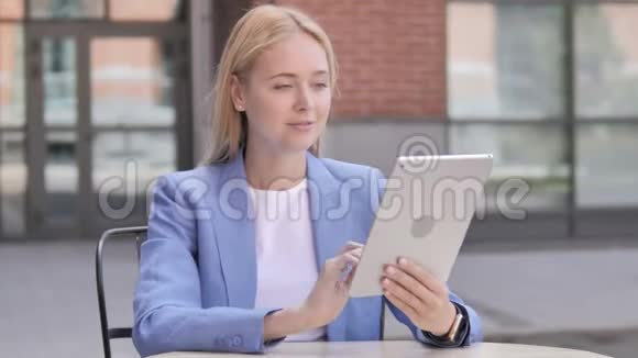 年轻女商人坐在户外桌上的视频聊天视频的预览图