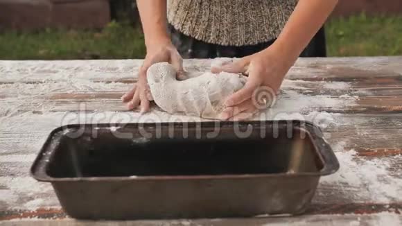 一个年轻的女人把面团放进饼干切割机里烘焙自制面包视频的预览图