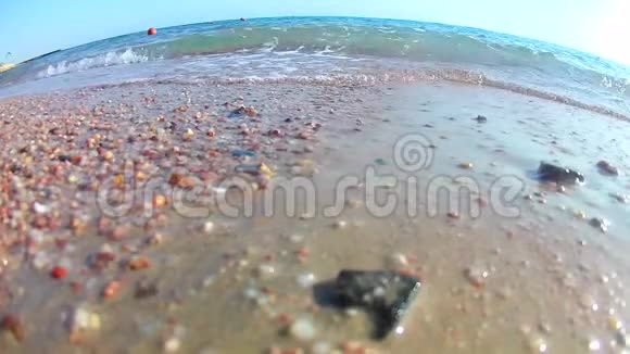 阳光明媚的一天海浪拍打着沙滩上的海浪红色的大海从下面的海岸可以看到超宽的圆形视频的预览图