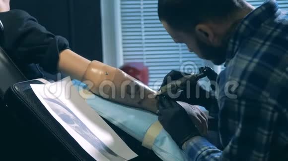 纹身沙龙工人画一个假肢仿生假肢视频的预览图