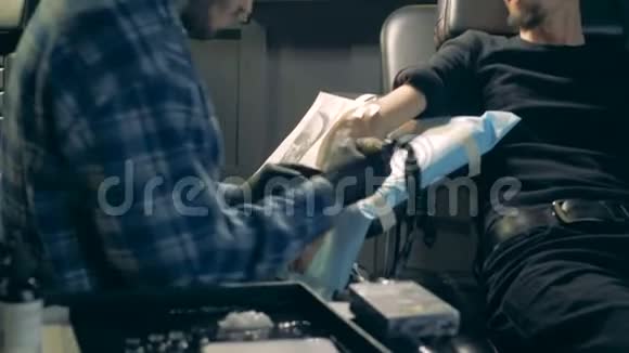 纹身大师在纹身手假体时使用设备视频的预览图