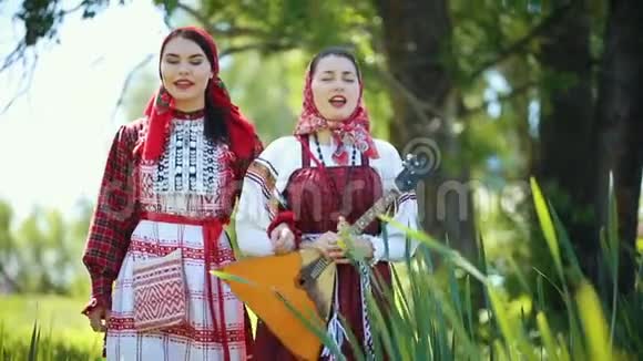两个身穿俄罗斯传统服装的年轻女子在田里散步唱歌视频的预览图