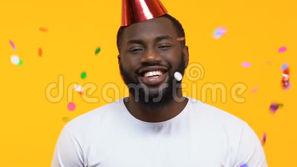 快乐的非裔美国人戴着派对帽在飘落的五彩纸屑下生日惊喜视频的预览图