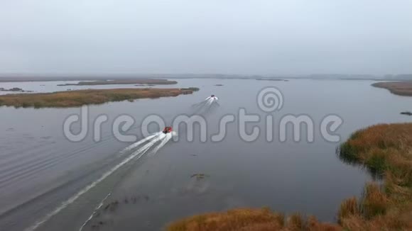 渔夫乘蓝色的船在早晨雾蒙蒙的时候钓鱼渔人用竹子建造的传统房屋视频的预览图