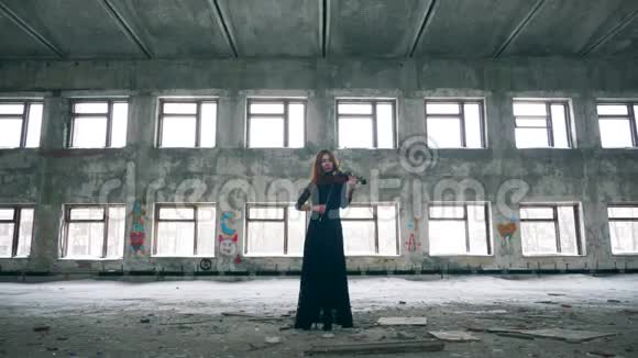 女人站在破败的大楼里拉小提琴视频的预览图
