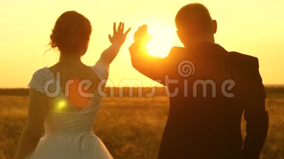 一男一女在夕阳下用手秀出一颗心浪漫之旅中的恋人团队合作视频的预览图