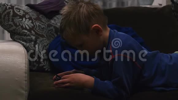 男孩躺在沙发上打电话视频的预览图
