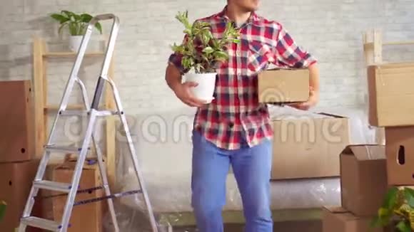 一个快乐的年轻人手里拿着一朵花和一个盒子的肖像移动的概念视频的预览图