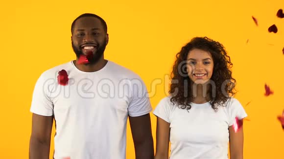 快乐的非裔美国夫妇站在心形纸屑下关系视频的预览图