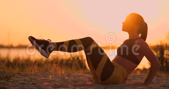 适合健康的女人在海滩上的瑜伽垫上伸展做运动腹部按摩训练和生活方式坐下视频的预览图