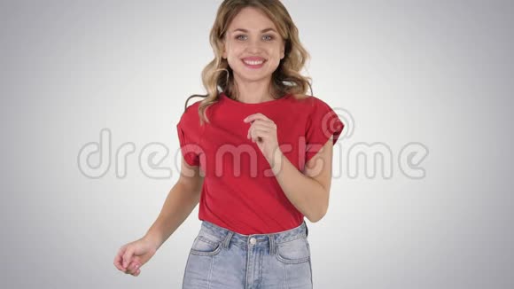 穿着红色t恤和牛仔裤的跑步女孩在渐变背景下微笑视频的预览图