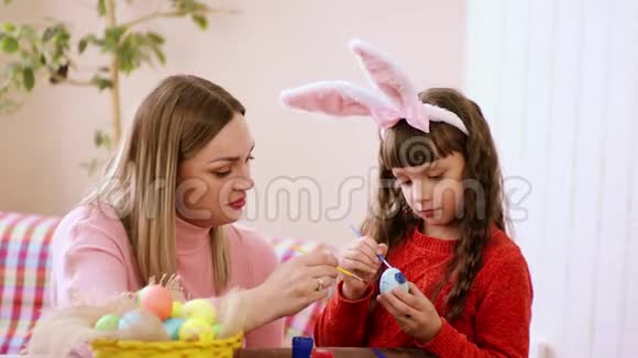 小女孩带着关心的目光在假期前带着复活节彩蛋然后带着温暖的吻给他的母亲视频的预览图
