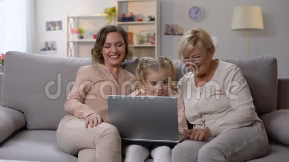 祖母和女儿教孩子使用笔记本电脑应用程序玩游戏视频的预览图