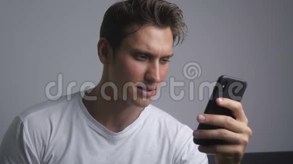 迷人的微笑男人使用智能手机发送社交媒体信息在室内喝咖啡视频的预览图