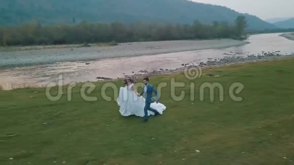 新婚夫妇在山河附近奔跑新郎和新娘审判意见视频的预览图