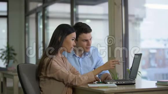 男女同事在笔记本电脑上看邮件变得非常开心视频的预览图
