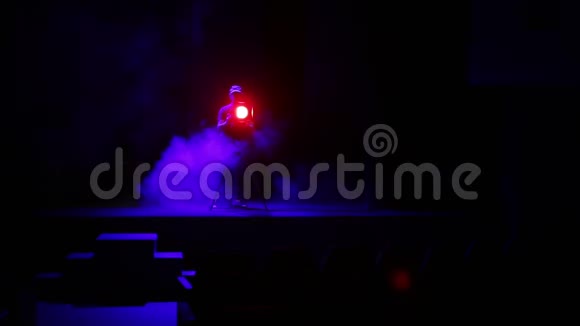 一个照明者用烟雾引导一束光线从舞台上的聚光灯照射到体育馆视频的预览图