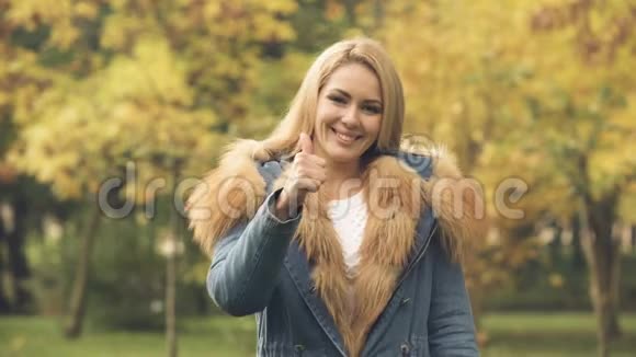 秋园微笑竖起大拇指的快乐女人社会保险视频的预览图