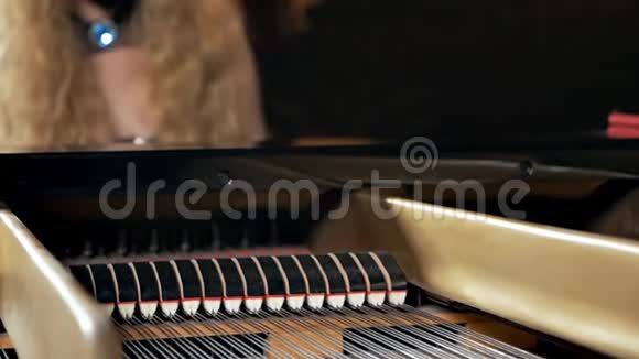 一个穿着黑色连衣裙脸上戴着面具的女孩弹钢琴不寻常的音乐表演钢琴曲视频的预览图