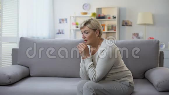 沮丧的老年妇女独自坐在家里困难的时光分手的悲伤视频的预览图