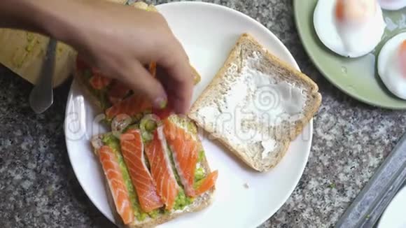 用牛油果番茄和熏三文鱼在白色盘子里做早餐视频的预览图