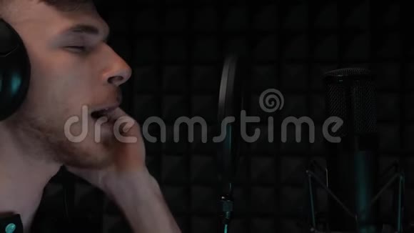 有魅力的唱歌男孩留着胡子在专业录音室排练流行男艺术家录音声音视频的预览图