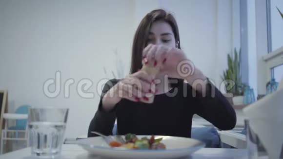 红光美甲盐少女画像坐在温馨的餐厅里她美味的食欲盘视频的预览图