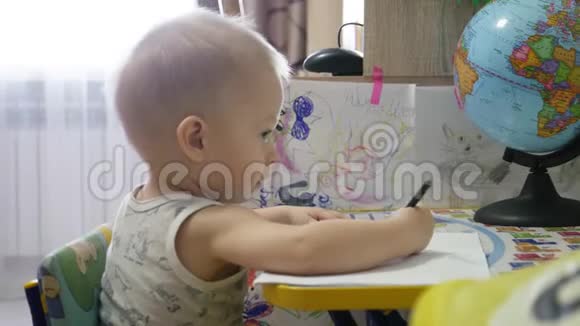 可爱的小男孩在家绘画1岁幼儿小男孩用铅笔绘画快乐的学龄前儿童创意游戏视频的预览图