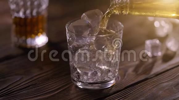 酒保把威士忌从瓶子里倒入玻璃杯里放在乡村木桌上视频的预览图
