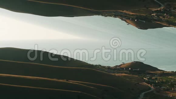 临海的青山小镇与蓝天交相辉映的镜面超现实鸟瞰图视频的预览图