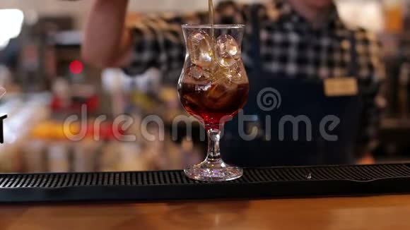 酒保把一杯可乐倒进酒吧里的一杯空冰里视频的预览图