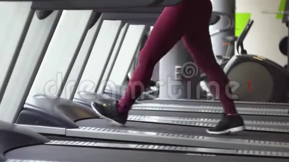 年轻女孩在健身房跑步机上跑步视频的预览图