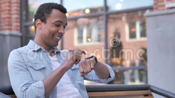 非洲男人使用智能手表户外视频的预览图