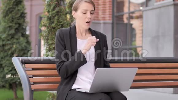 年轻女商人在户外工作时咳嗽视频的预览图