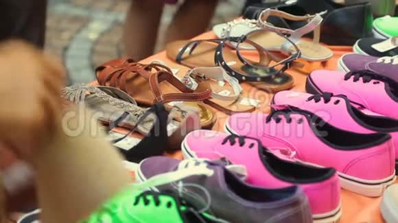 微笑的度假男游客在市场上看手工皮鞋视频的预览图