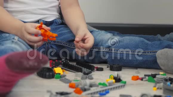快乐家庭男孩和女孩坐在地板上收集建设者孩子们玩玩具团队合作的概念小弟弟和视频的预览图