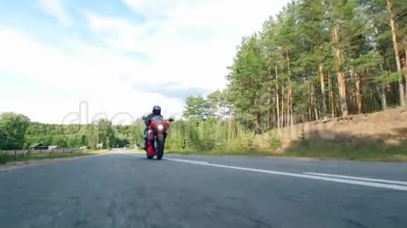 戴头盔的骑自行车的人骑摩托车在马路上行驶视频的预览图
