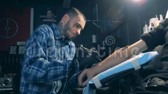 男人用机器在沙龙里画假手上的纹身视频的预览图
