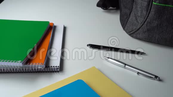 学生少年在白桌子上收集一个灰色的书包上学视频的预览图