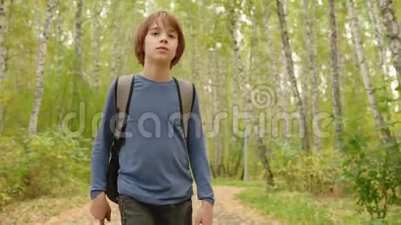 带背包的少年在秋天公园散步视频的预览图