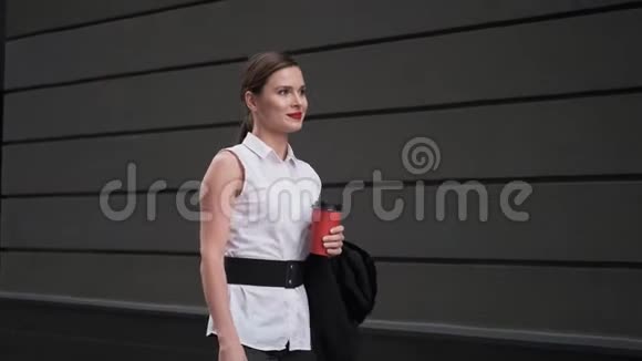 自信的商界女性拿着一杯纸杯咖啡走在街上穿着商务服的年轻女子视频的预览图