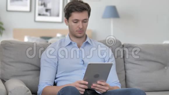 坐在沙发上的帅哥在桌上的在线视频聊天视频的预览图