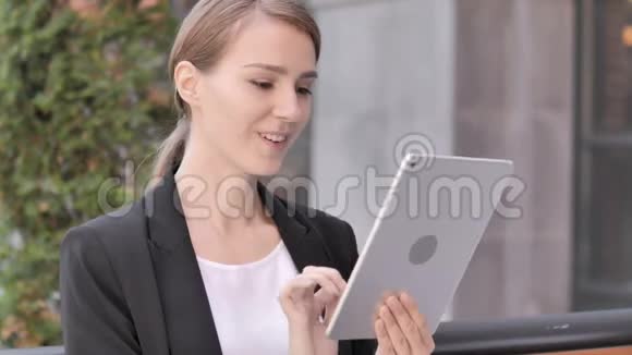 年轻女商人坐在户外桌上的视频聊天视频的预览图