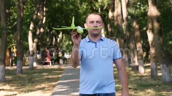 一个人在一个夏天的公园里休息在风中扫着一架玩具飞机回忆着童年视频的预览图