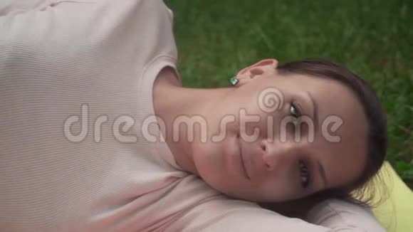 一位孕妇在公园里做瑜伽躺在左边的一个姿势阿萨娜沙瓦萨纳一个死男人的姿势视频的预览图