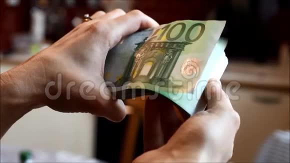 女人手里拿着100欧元的钞票视频的预览图